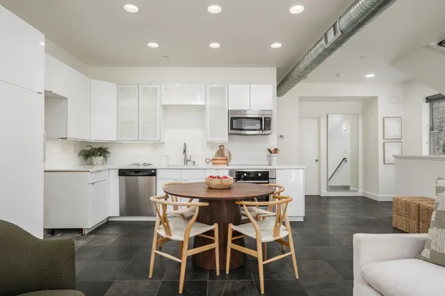 a kitchen with kitchen island white cabinets and stainless steel appliances