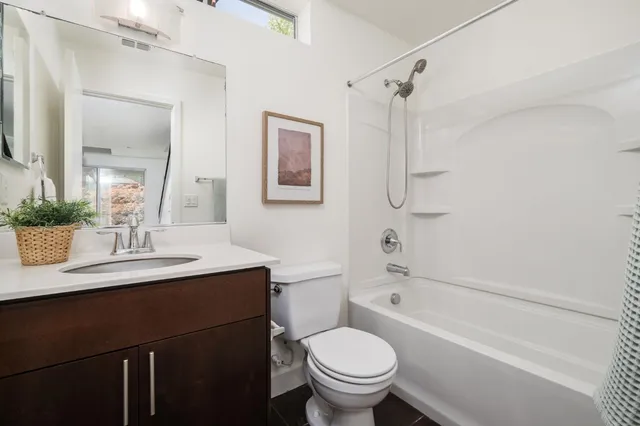 a bathroom with a sink toilet vanity and shower