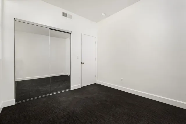 an empty room with wooden floor and cabinet
