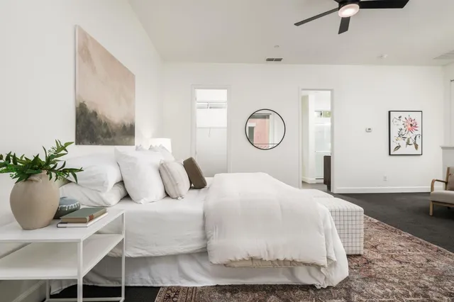 a bedroom with a bed and a potted plant