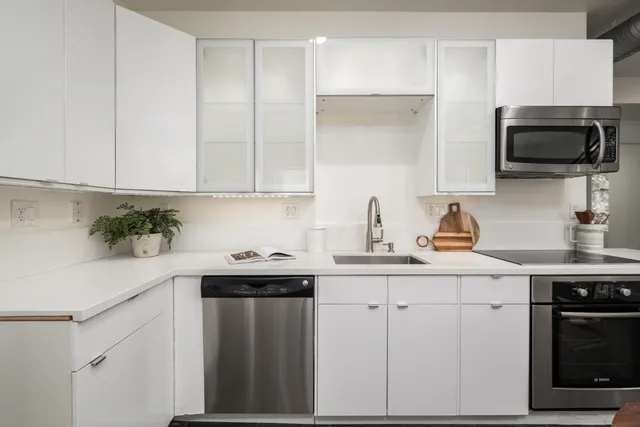 a kitchen with appliances a sink and cabinets