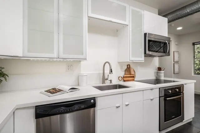 a kitchen with stainless steel appliances granite countertop a sink stove a microwave and cabinets