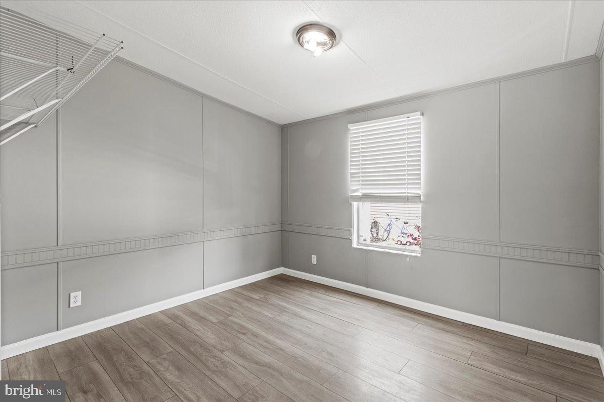 308 Berts Drive Lothian, MD 20711 - Photo 21 of 26 a view of empty room with wooden floor and fan