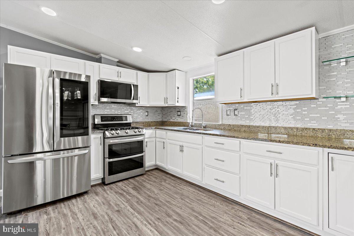308 Berts Drive Lothian, MD 20711 - Photo 7 of 26 a kitchen with stainless steel appliances granite countertop a stove a sink and a refrigerator
