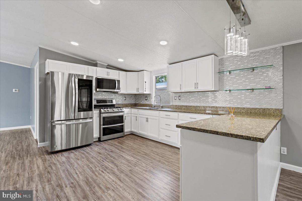 308 Berts Drive Lothian, MD 20711 - Photo 8 of 26 a kitchen with kitchen island granite countertop a sink stainless steel appliances and cabinets