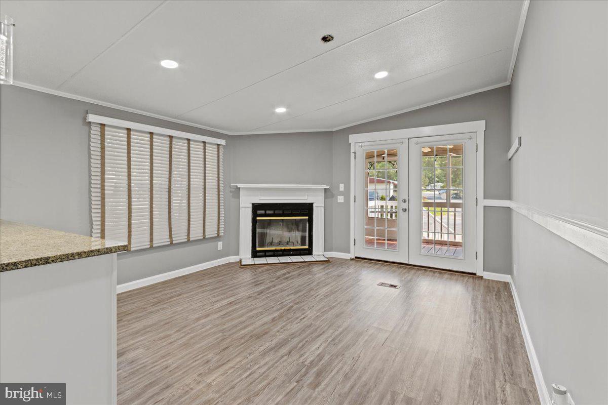 308 Berts Drive Lothian, MD 20711 - Photo 10 of 26 an empty room with wooden floor fireplace and windows