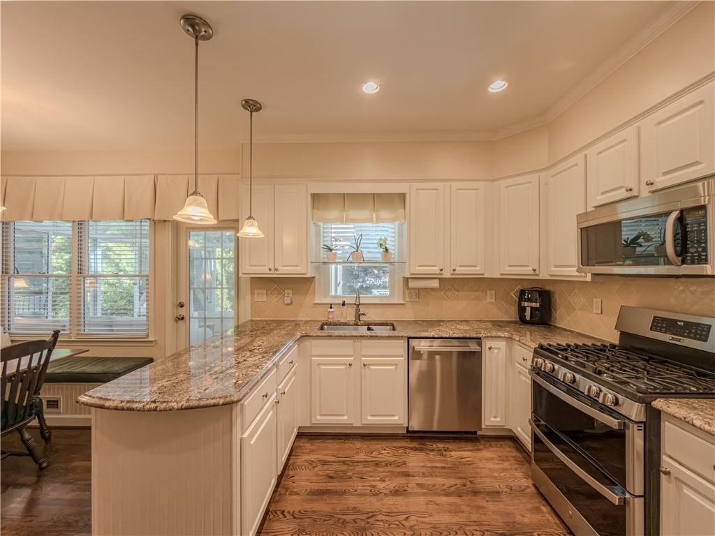 4284 Cedar Bluff Way Southwest Lilburn, GA 30047 - Photo 27 of 62 a kitchen with stainless steel appliances granite countertop a stove a sink and a refrigerator