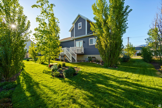 681 Island Road Morgan, UT 84050 - Photo 33 of 49 Spacious rear yard featuring a verdant lawn, mature trees, and established garden beds