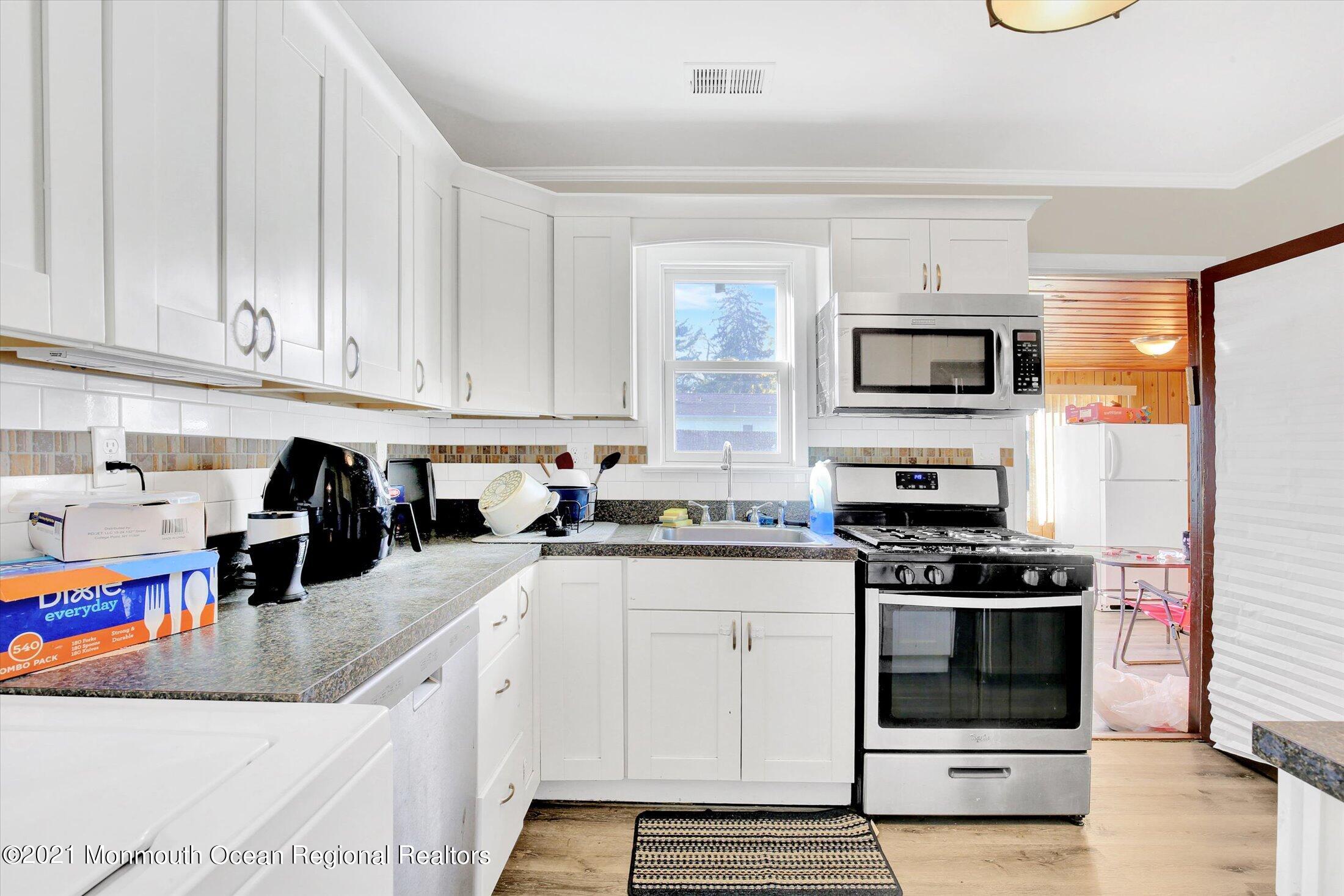 972 Woodgate Avenue Long Branch, NJ 07740 - Photo 9 of 20 a kitchen with stainless steel appliances granite countertop a stove a sink and a white refrigerator