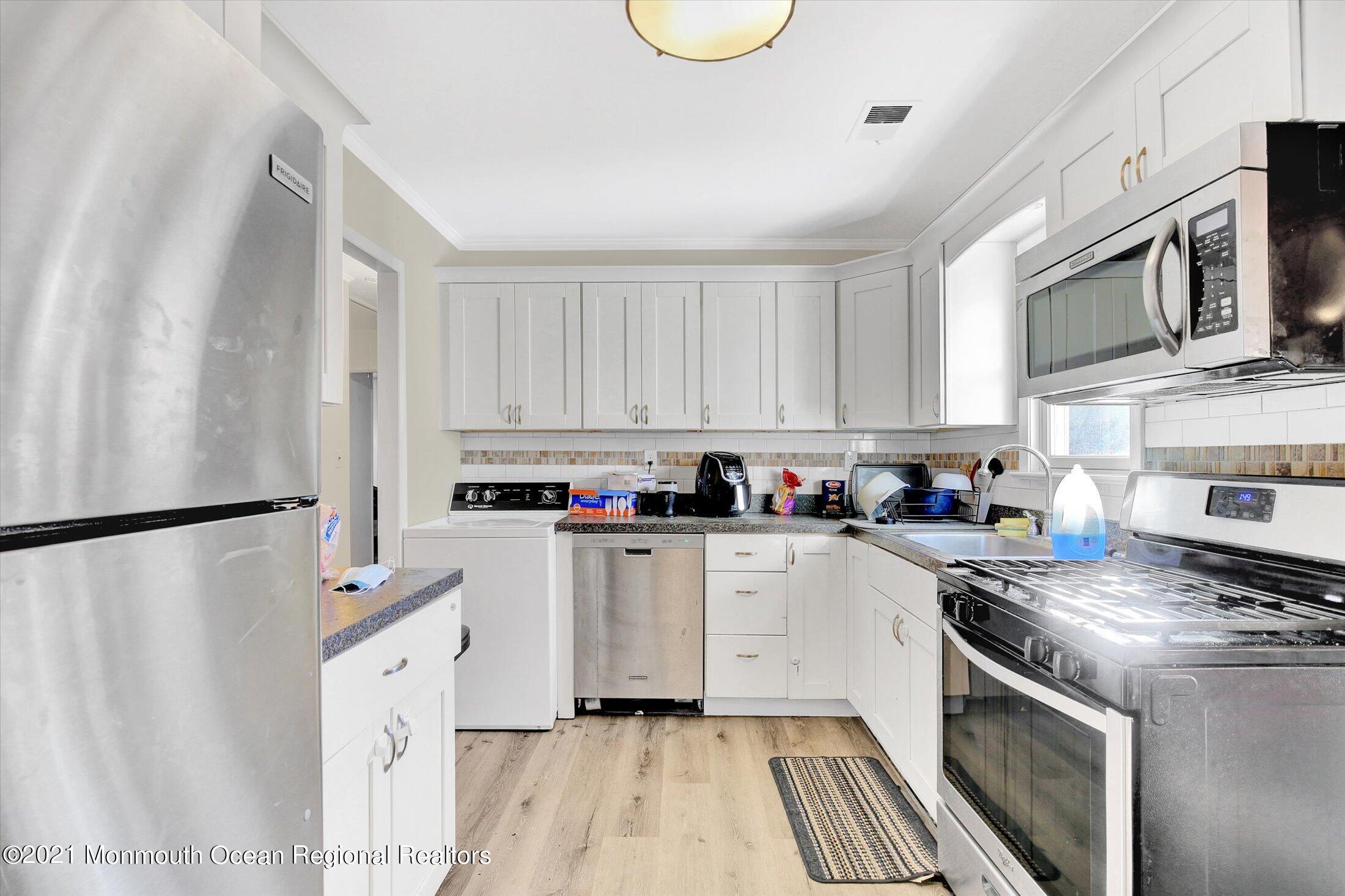 972 Woodgate Avenue Long Branch, NJ 07740 - Photo 10 of 20 a kitchen with stainless steel appliances a refrigerator a stove a sink and white cabinets