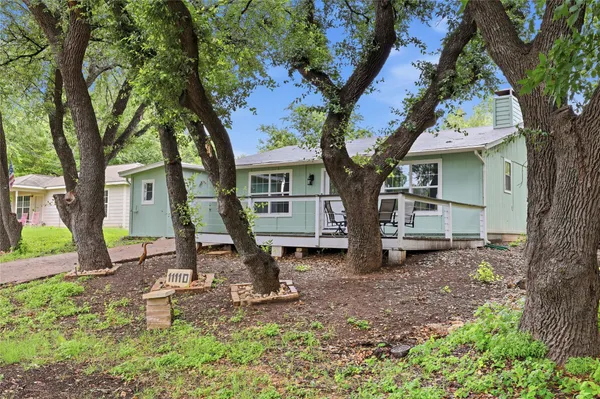 a front view of a house with a tree