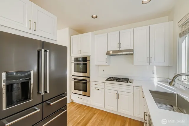 a kitchen with white cabinets and stainless steel appliances