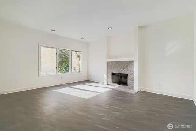 an empty room with windows and a fireplace