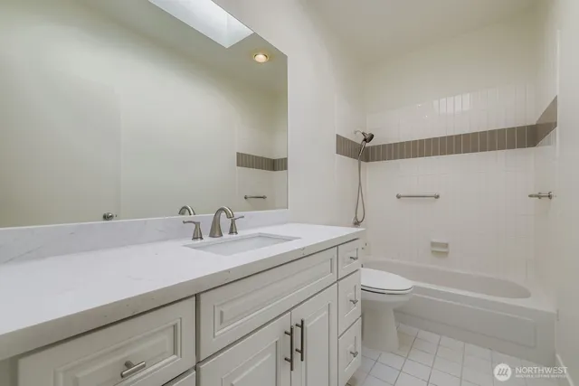 a bathroom with a granite countertop sink a toilet and bathtub
