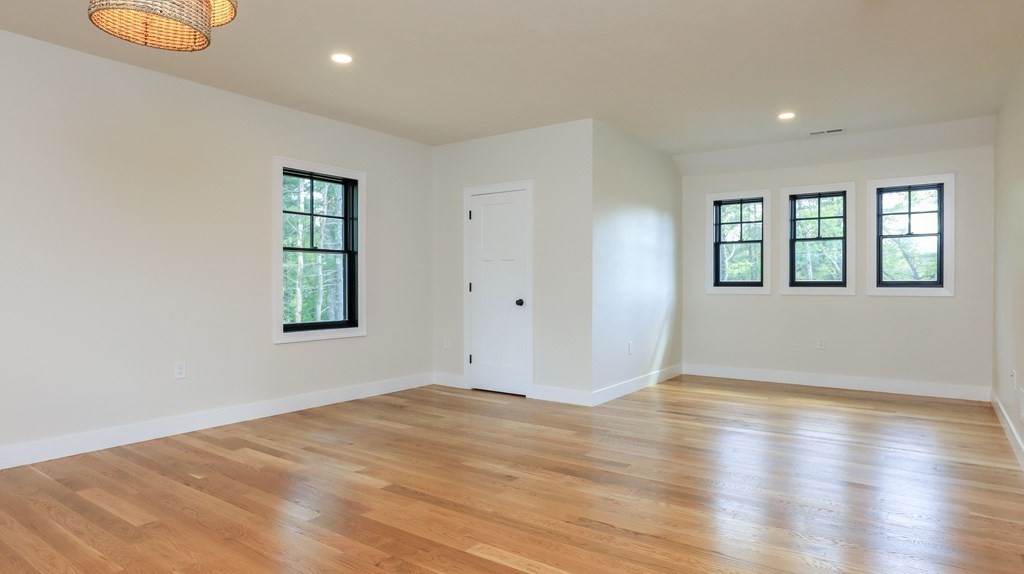 340 Longley Road Groton, MA 01450 - Photo 8 of 20 an empty room with wooden floor and windows