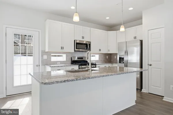 a kitchen with stainless steel appliances granite countertop a refrigerator a stove a sink and a granite counter tops