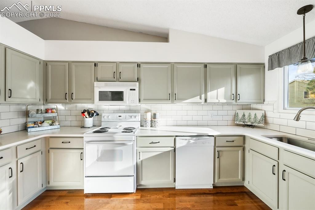5145 Slickrock Drive Colorado Springs, CO 80923 - Photo 8 of 33 a kitchen with white cabinets sink and stainless steel appliances