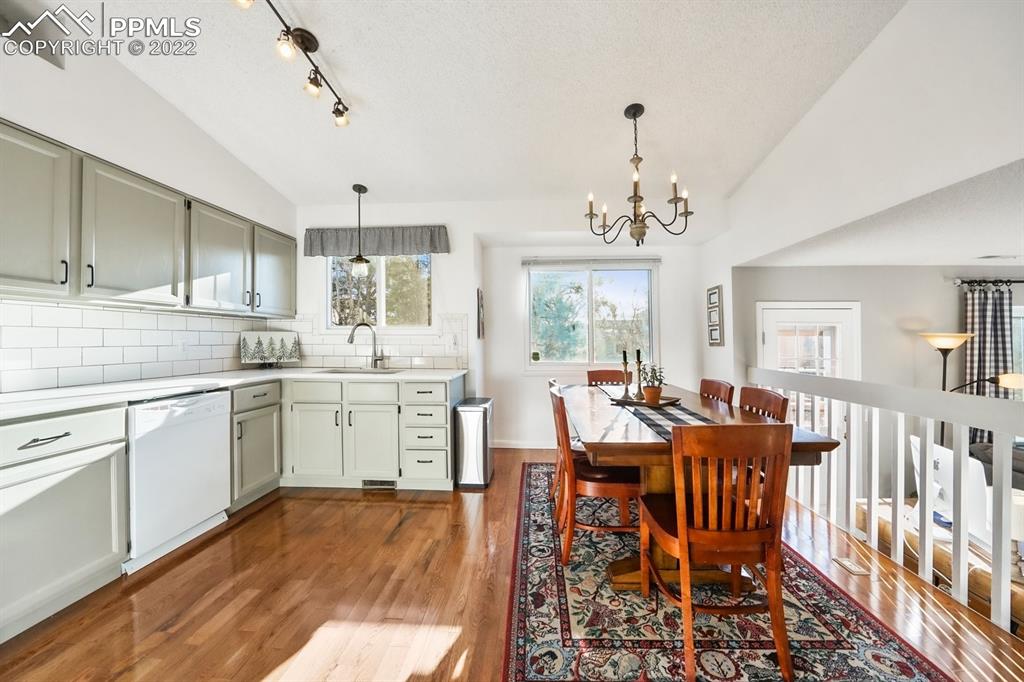 5145 Slickrock Drive Colorado Springs, CO 80923 - Photo 9 of 33 a view of a dining room and livingroom with furniture wooden floor a chandelier