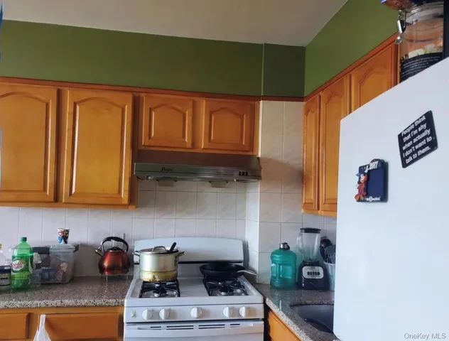 a kitchen with stainless steel appliances granite countertop a stove and a refrigerator
