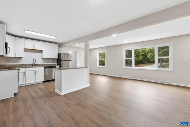 a view of kitchen with wooden floor and electronic appliances