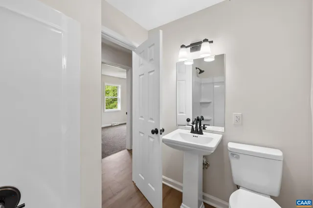 a bathroom with a sink toilet and a mirror