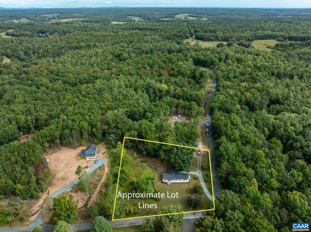 an aerial view of residential houses with outdoor space and trees