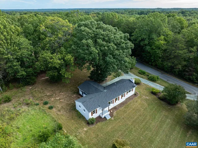 an aerial view of a house with a yard basket ball court and outdoor seating