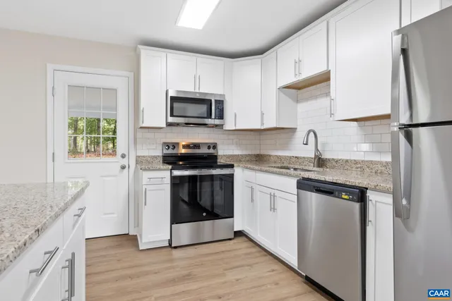 a kitchen with stainless steel appliances granite countertop a refrigerator stove microwave and sink