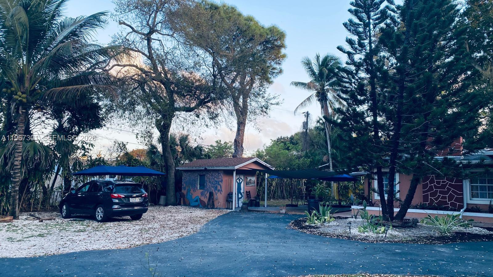 1760 Northeast 144th Street Miami, FL 33181 - Photo 6 of 83 a view of backyard with wooden fence and a large tree
