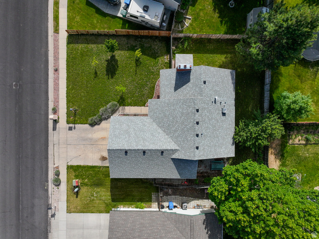 1218 East 100 South Logan, UT 84321 - Photo 3 of 23 Residential property featuring an asphalt shingle roof, paved driveway, and established green lawns in both the front and rear