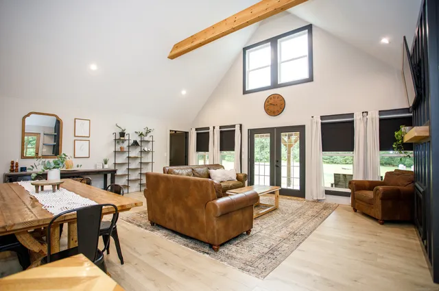 a living room with fireplace furniture and a large window