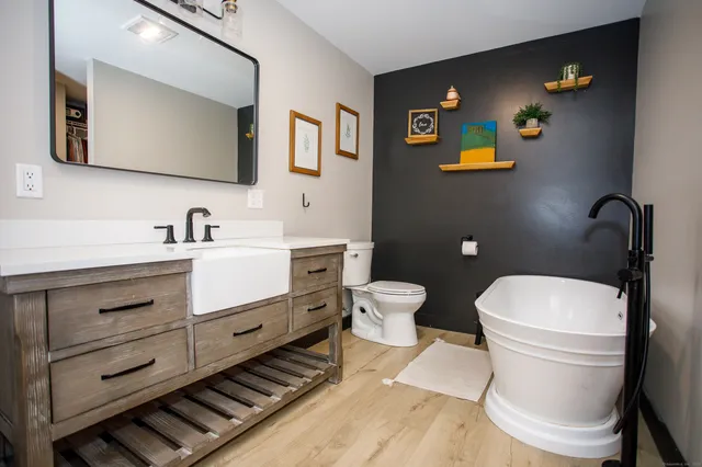 a bathroom with a toilet a sink and mirror
