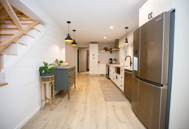 a kitchen with stainless steel appliances granite countertop a refrigerator a oven a sink and dishwasher