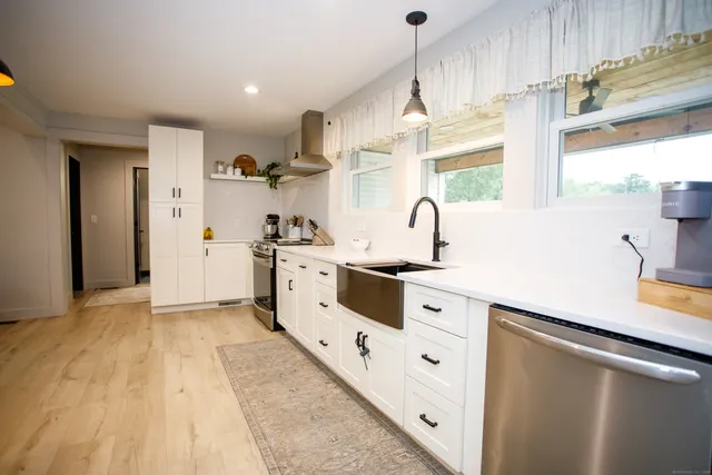 a kitchen with white cabinets and white appliances