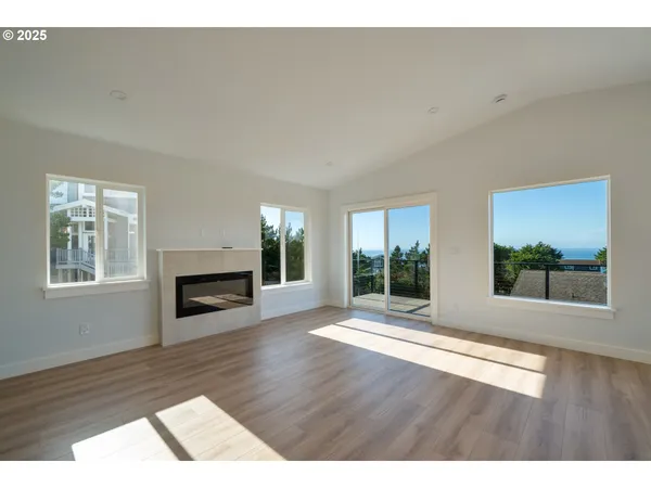 a view of a livingroom with wooden floor and a fireplace