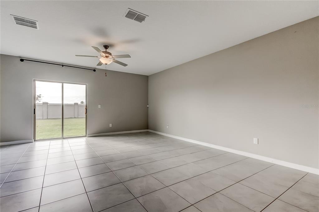 31592 Barrel Wave Way Wesley Chapel, FL 33545 - Photo 21 of 62 an empty room with windows and ceiling fan