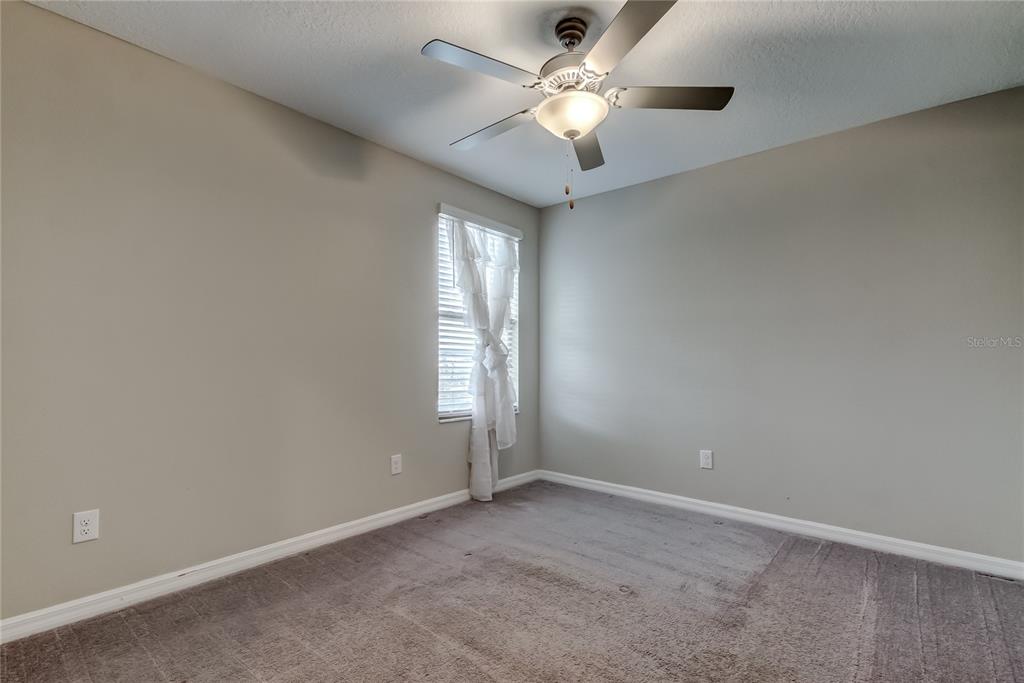 31592 Barrel Wave Way Wesley Chapel, FL 33545 - Photo 50 of 62 an empty room with a chandelier fan and windows