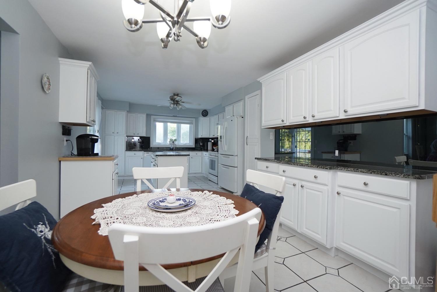 60 Annette Drive Edison, NJ 08820 - Photo 28 of 69 a kitchen with stainless steel appliances granite countertop a dining table chairs and white cabinets