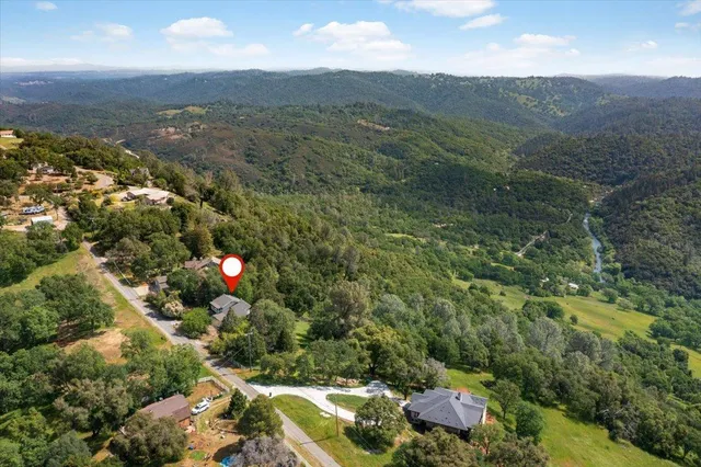an aerial view of residential houses with outdoor space and trees