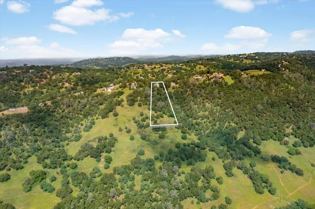 a view of a white house with large windows and a yard