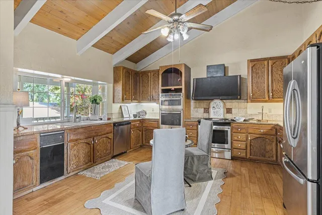 a kitchen with granite countertop stainless steel appliances and wooden cabinets