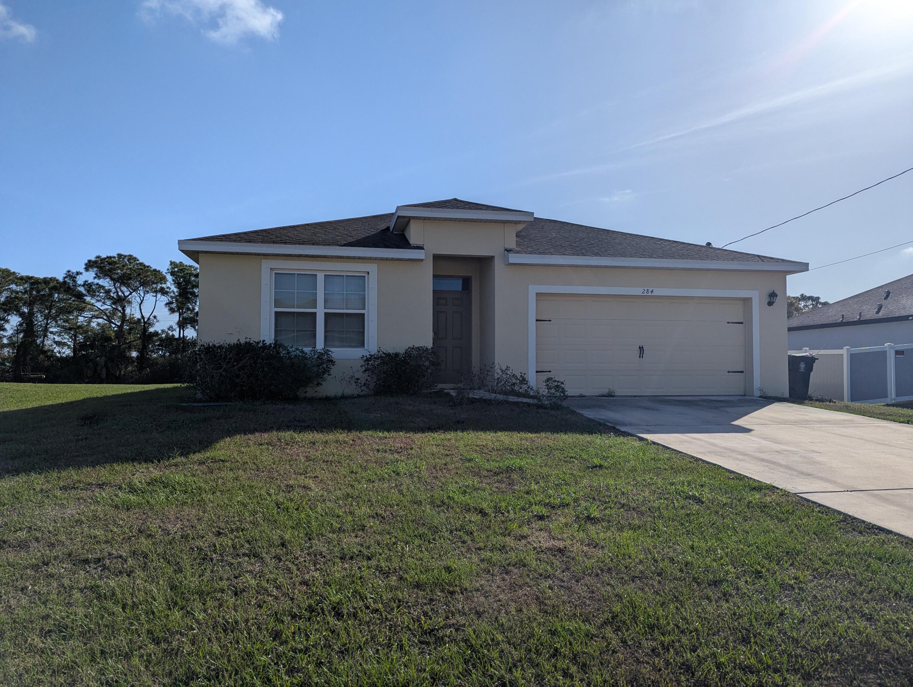 284 Southwest Ridgecrest Drive Port St. Lucie, FL 34953 - Photo 1 of 16 a house view with a garden space