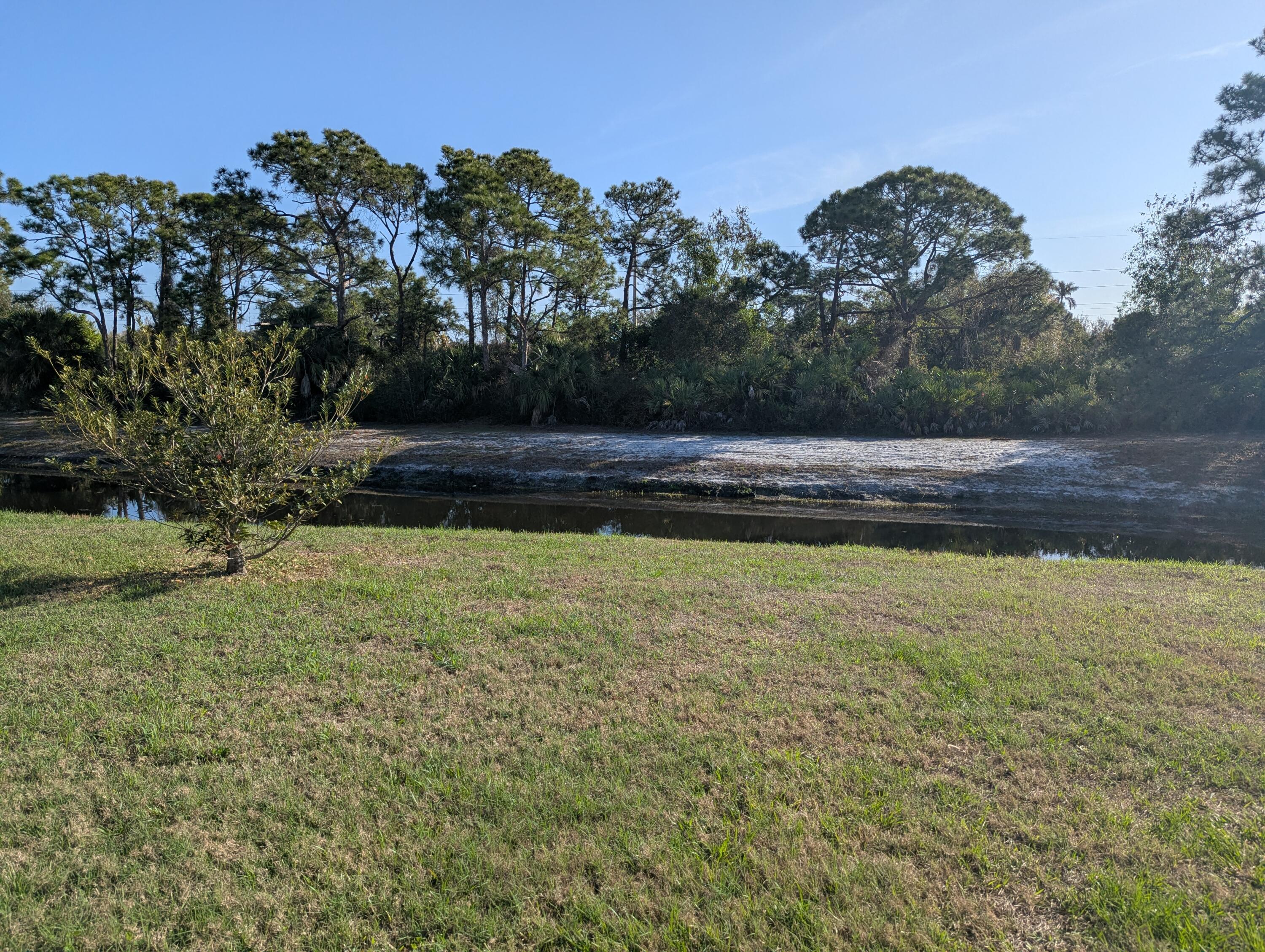 284 Southwest Ridgecrest Drive Port St. Lucie, FL 34953 - Photo 16 of 16 a view of swimming pool next to a yard