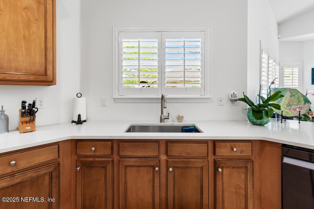 3139 Ashgrove Road Jacksonville, FL 32226 - Photo 29 of 81 a kitchen with stainless steel appliances granite countertop a sink a potted plant and white cabinets