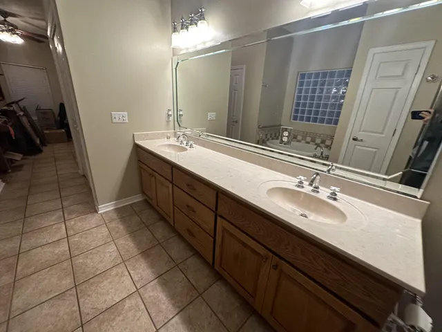 a spacious bathroom with a double vanity sink a mirror and a shower