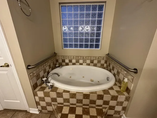 a view of an empty room with window and chandelier fan