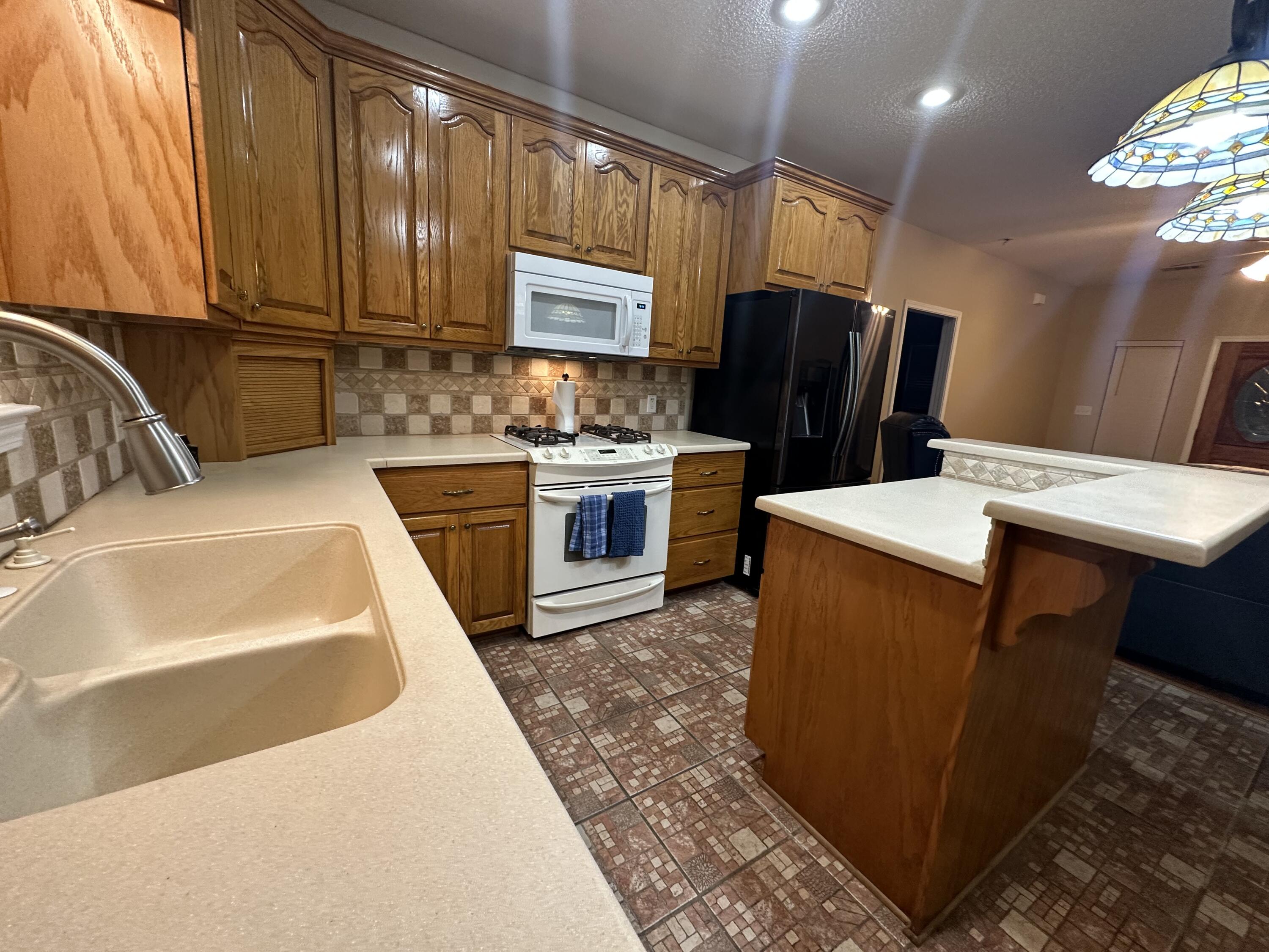5771 Flora Lee Lane Crestview, FL 32539 - Photo 60 of 66 a kitchen with stainless steel appliances granite countertop a sink stove and refrigerator