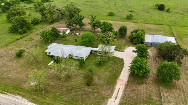 an aerial view of a house with a yard and lake view