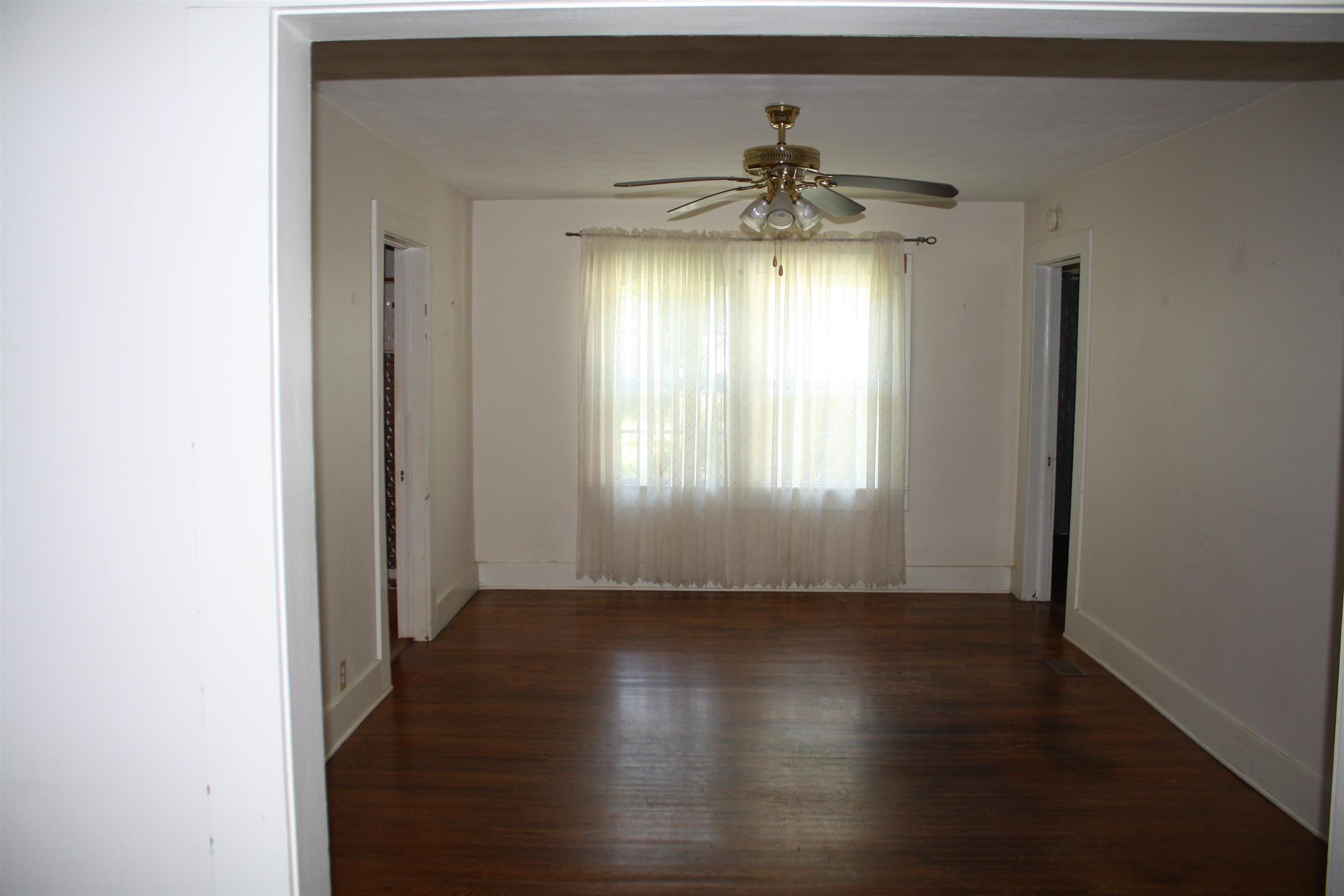 611 Fall River Road Lawrenceburg, TN 38464 - Photo 9 of 18 an empty room with wooden floor chandelier and windows
