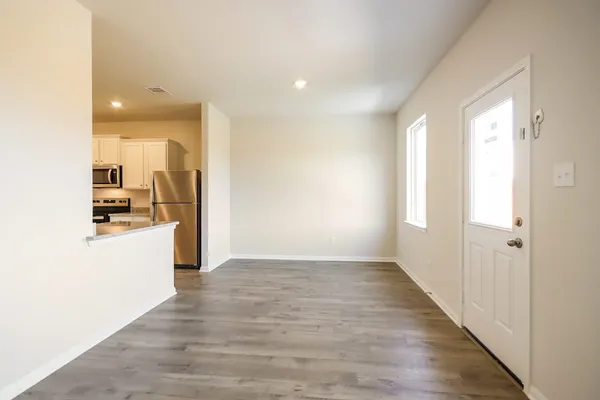 a large kitchen with a stove top oven a sink dishwasher a refrigerator and a microwave oven with wooden floor